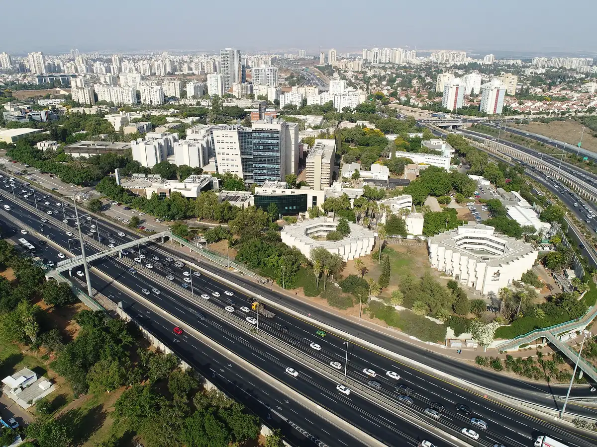 Aerial view of the Bar-Ilan University campus beside Route 4, with residential towers beyond